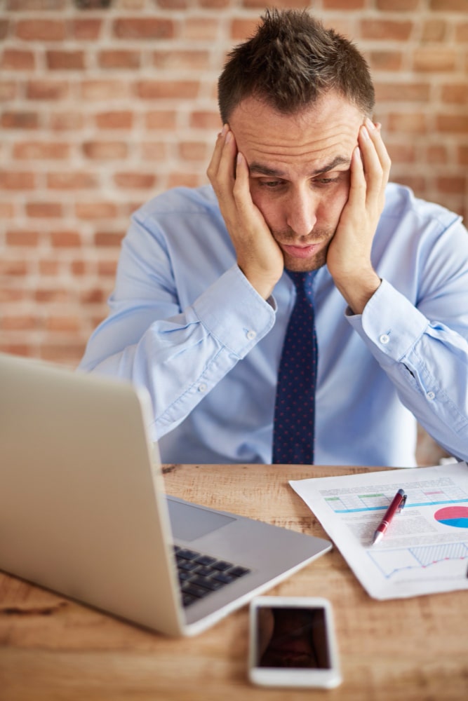 Person arbeitet am Schreibtisch mit Laptop und Unterlagen zur Vorbereitung für ein Audit Medizinprodukte nach MDR und IVDR.