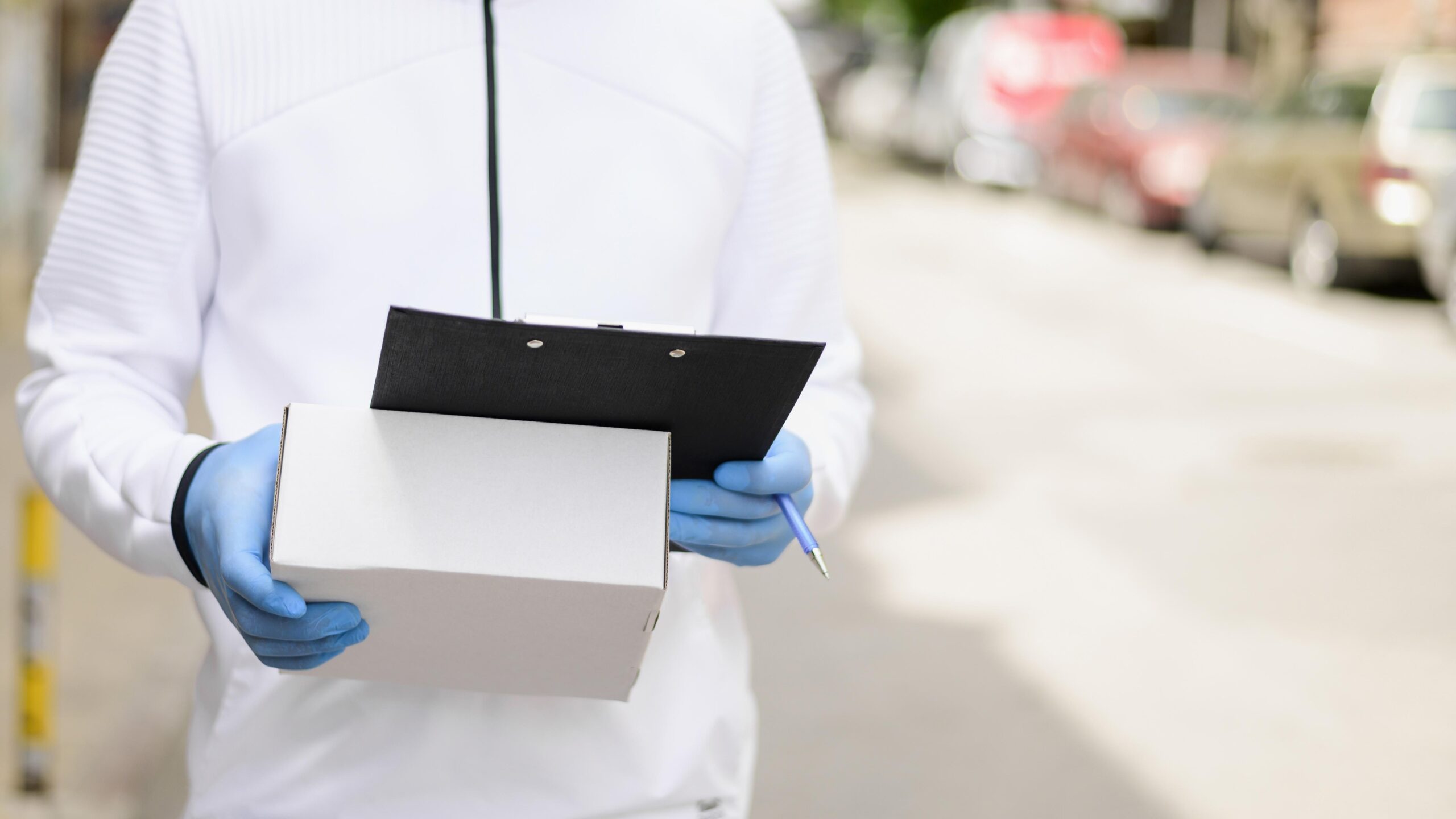 Person hält ein Produkt und ein Klemmbrett: Prüfung der Eigenmarke bei Medizinprodukten und der UDI-DI